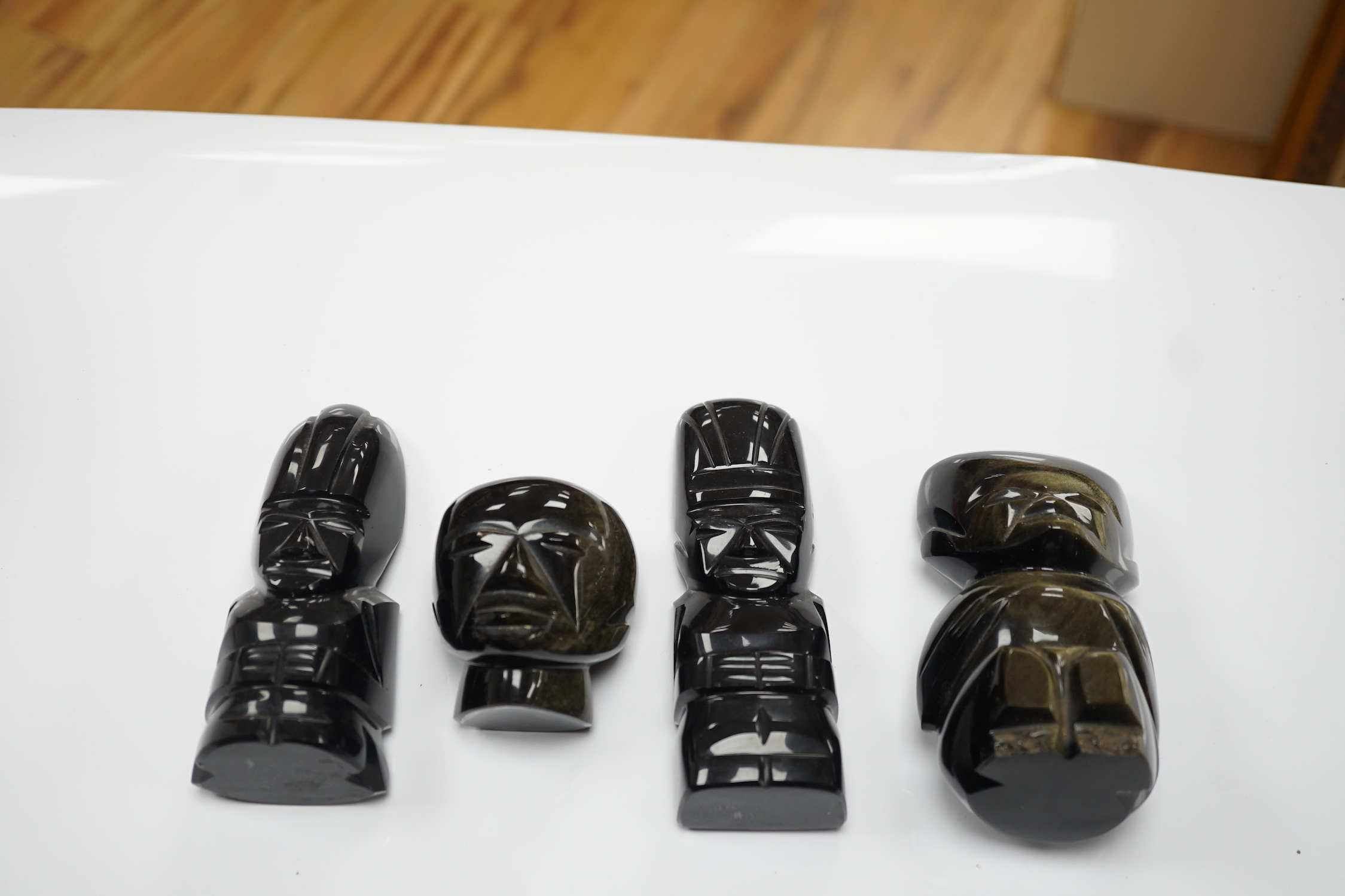 Three 20th century Aztec Mayan style carved obsidian stylised figures and a similar mask (4) tallest 15cm